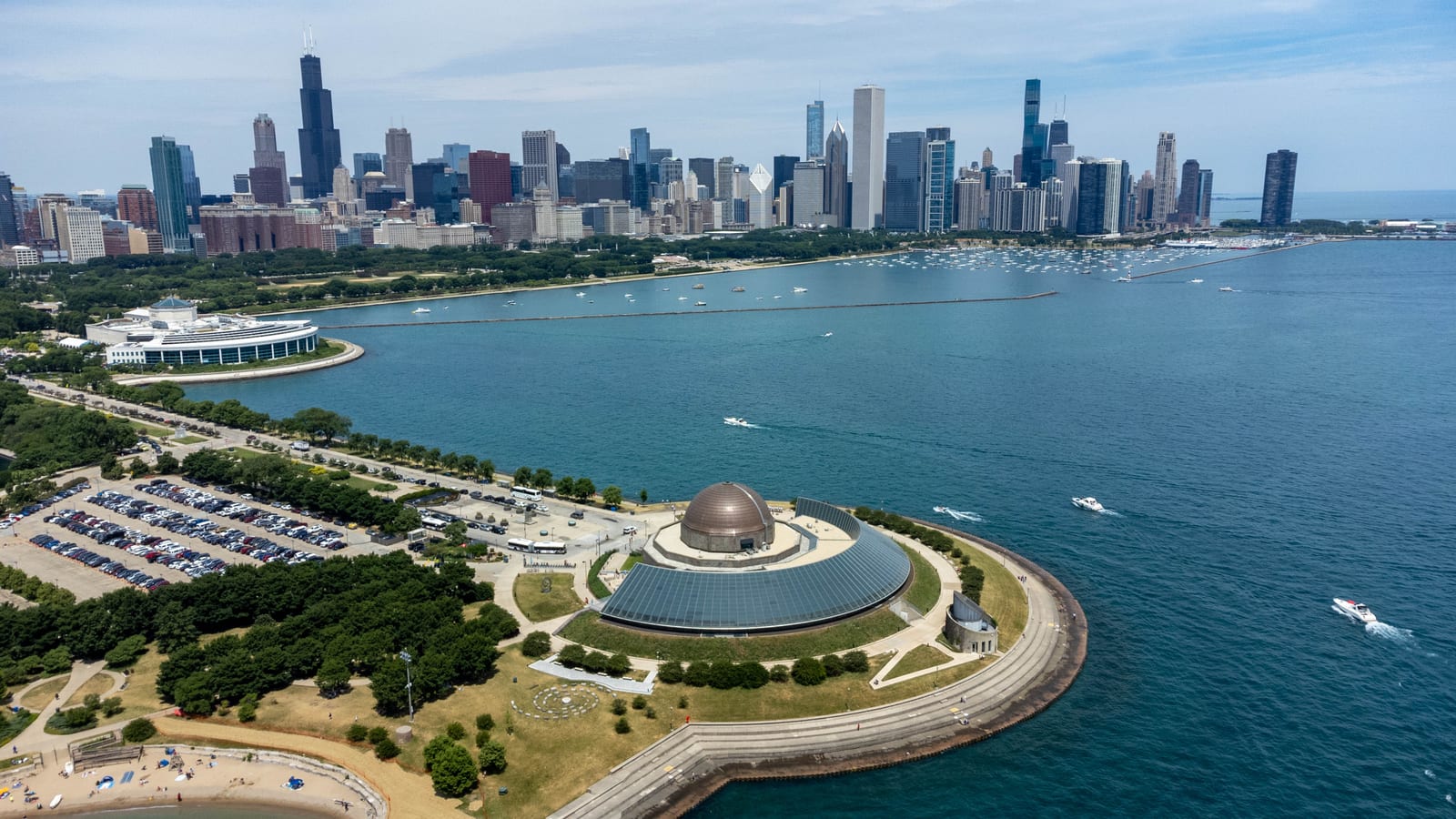 The Chicago skyline rising over Lake Michigan with the Adler Planetarium dome in the foreground